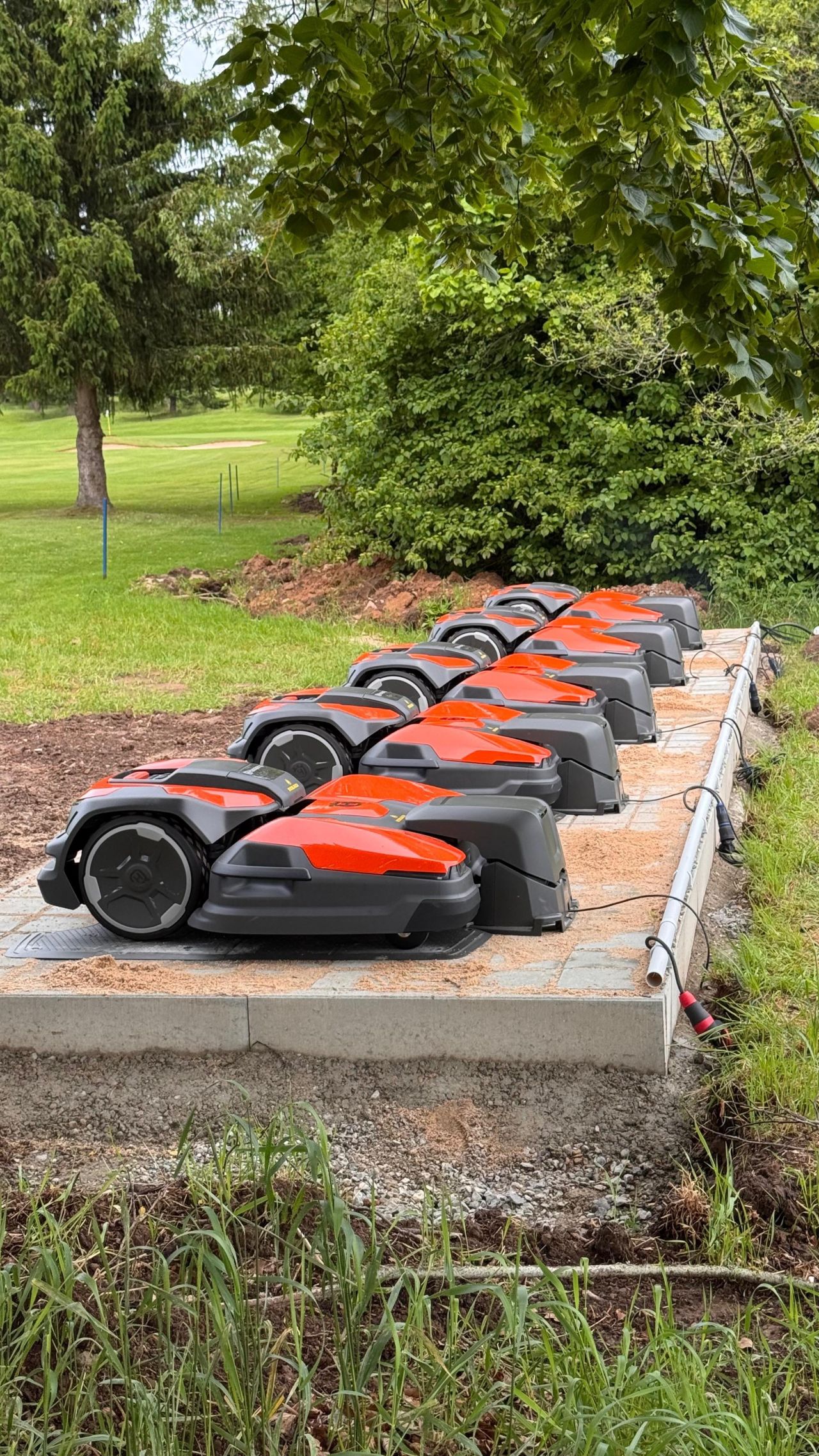 Professional robotic mower fleet operations showcase - multiple mowers lined up and ready for deployment